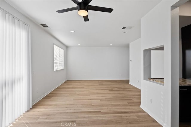 spare room with ceiling fan and light wood-type flooring