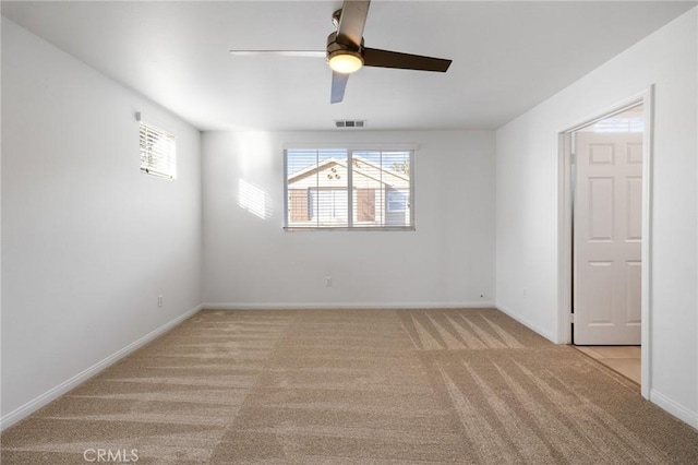 empty room featuring ceiling fan and light colored carpet