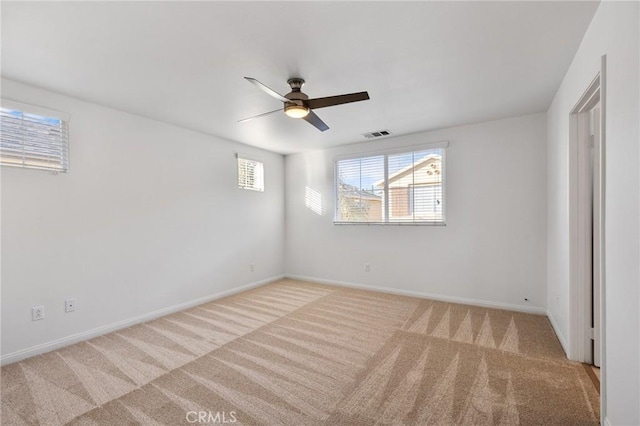 carpeted spare room with ceiling fan