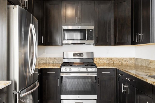 kitchen with light stone counters, dark brown cabinetry, and appliances with stainless steel finishes