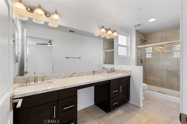 bathroom with ceiling fan, tile patterned flooring, vanity, a shower with shower door, and toilet