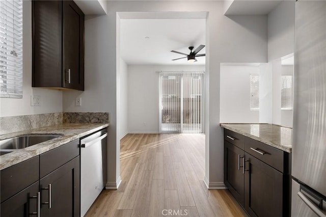 kitchen with dark brown cabinetry, light stone countertops, and stainless steel dishwasher