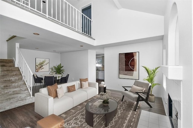 living room with dark hardwood / wood-style flooring and a towering ceiling