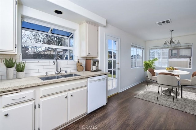 kitchen with pendant lighting, sink, dishwasher, tasteful backsplash, and white cabinets