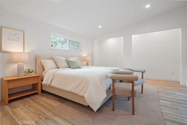 bedroom featuring lofted ceiling and light hardwood / wood-style floors