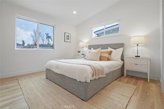 bedroom with vaulted ceiling and light wood-type flooring