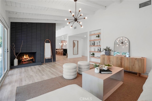 living room featuring built in features, plenty of natural light, a fireplace, and beam ceiling