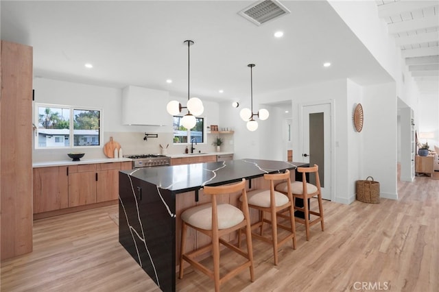 kitchen featuring range, light wood-type flooring, and a kitchen island