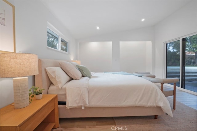 bedroom with light hardwood / wood-style floors, vaulted ceiling, multiple windows, and access to outside