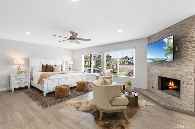 bedroom with ceiling fan and a fireplace