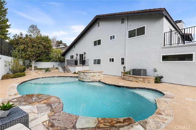 view of pool with a patio, central AC unit, a hot tub, and pool water feature