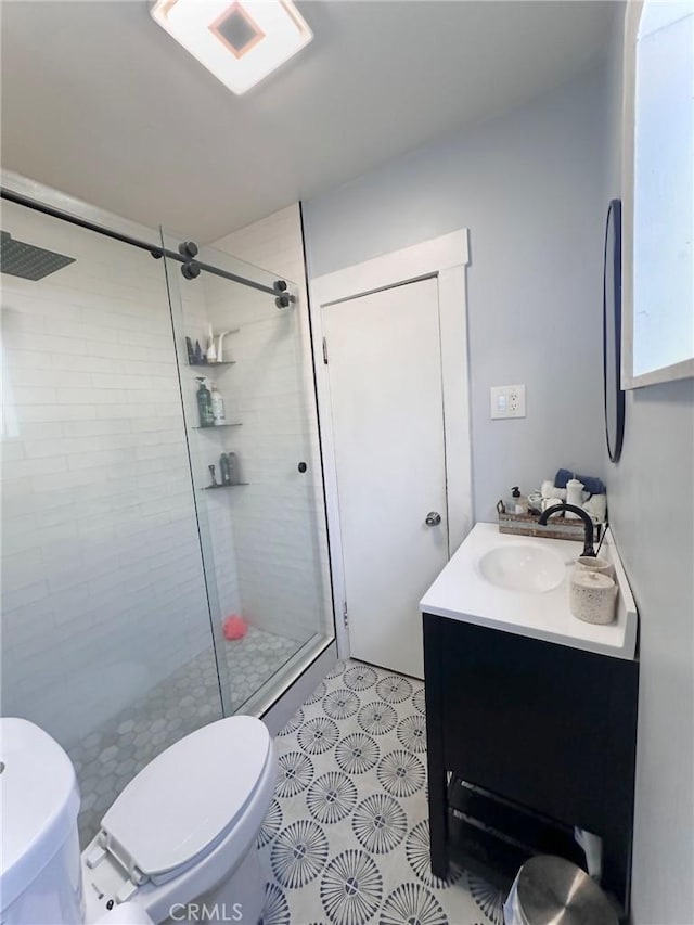 bathroom featuring vanity, a tile shower, and toilet