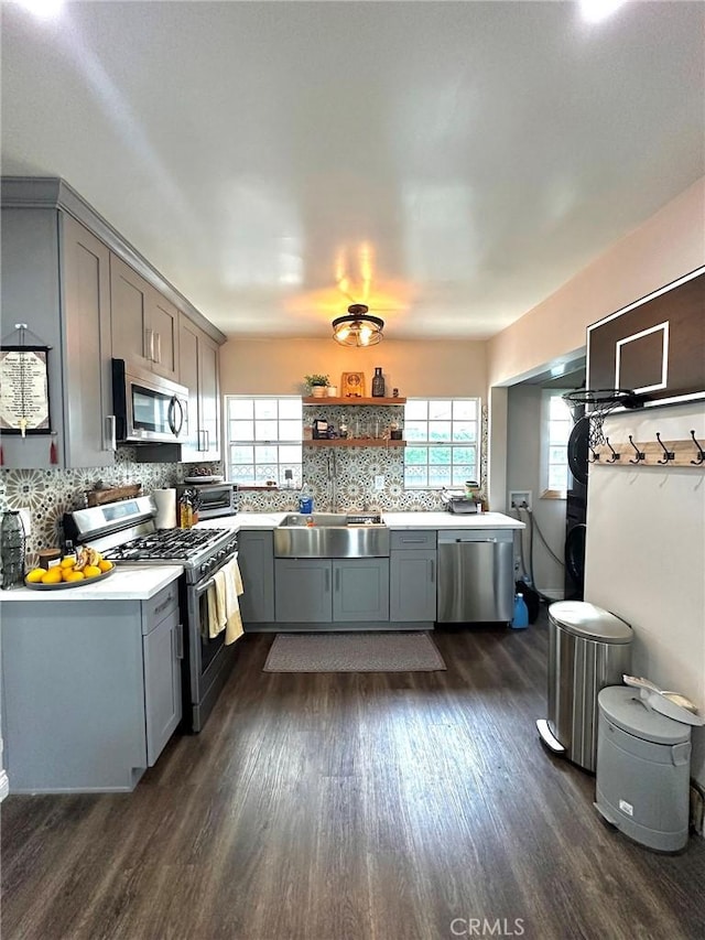 kitchen with stainless steel appliances, a wealth of natural light, and gray cabinetry