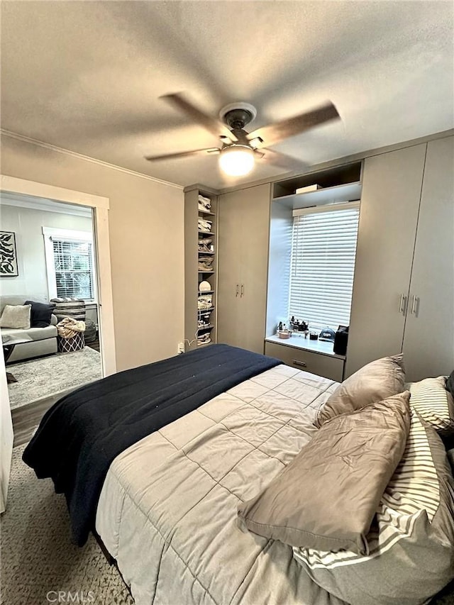 bedroom with ceiling fan, ornamental molding, and a textured ceiling