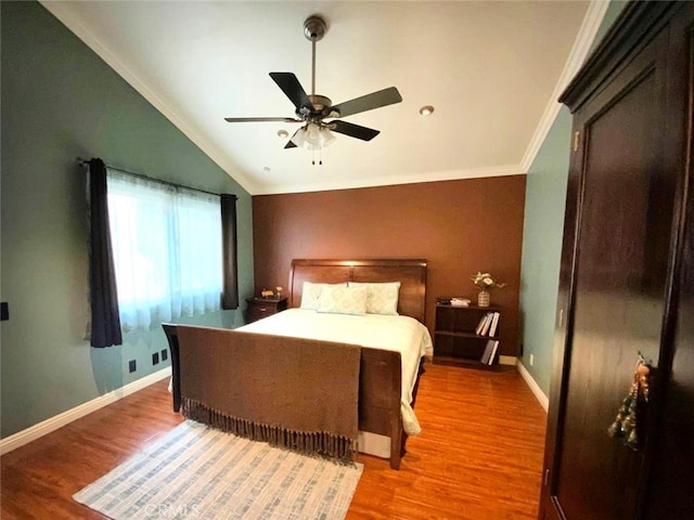 bedroom with ceiling fan, crown molding, vaulted ceiling, and wood-type flooring