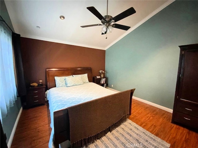 bedroom with vaulted ceiling, dark hardwood / wood-style floors, ceiling fan, and crown molding