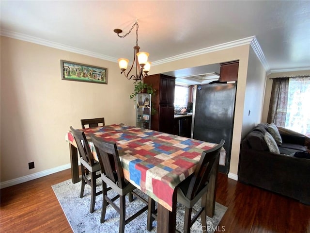 dining area with dark hardwood / wood-style flooring, crown molding, and a chandelier