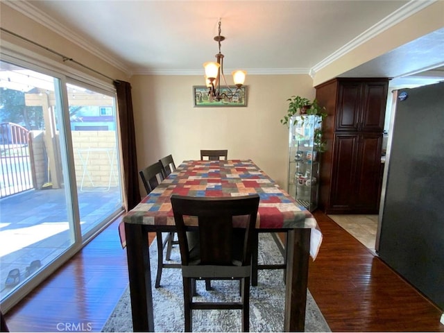 dining room with crown molding, a notable chandelier, and light wood-type flooring