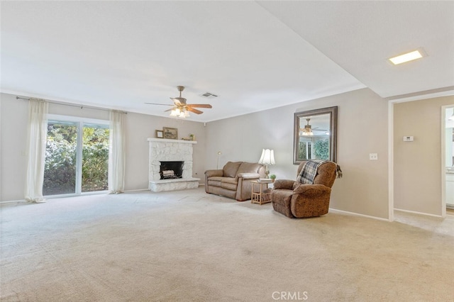 carpeted living room featuring ceiling fan and a fireplace