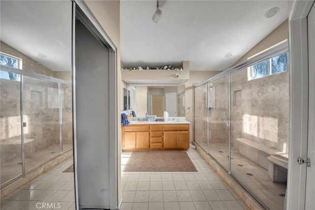 bathroom featuring tile patterned floors, a shower with door, vaulted ceiling, and vanity