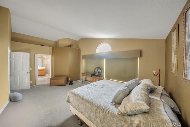 bedroom with lofted ceiling, carpet flooring, and ensuite bathroom