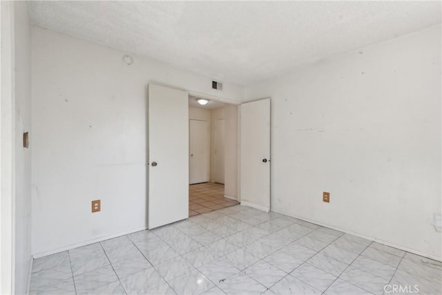 spare room with a textured ceiling