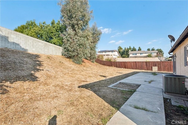 view of yard with central AC unit and a patio area