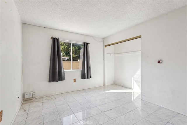 unfurnished bedroom featuring a closet and a textured ceiling