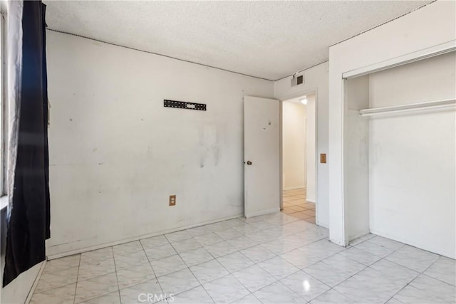 unfurnished bedroom featuring a textured ceiling and a closet