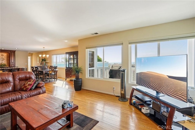 living room with a notable chandelier and light hardwood / wood-style floors