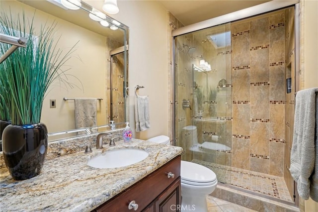 bathroom featuring vanity, a shower with shower door, tile patterned floors, and toilet