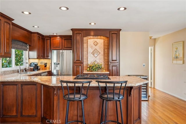 kitchen featuring sink, decorative backsplash, stainless steel appliances, and a center island