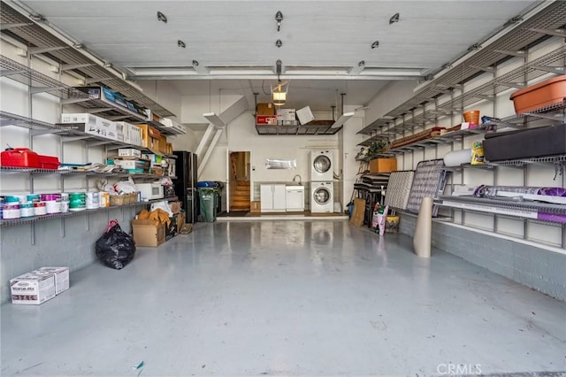 garage featuring stacked washer / dryer and a garage door opener