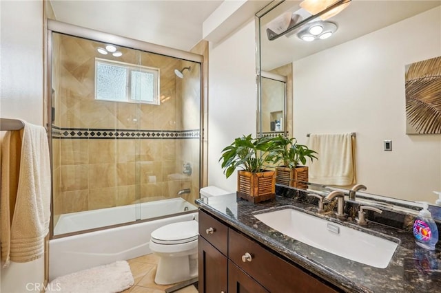 full bathroom with enclosed tub / shower combo, vanity, tile patterned floors, and toilet