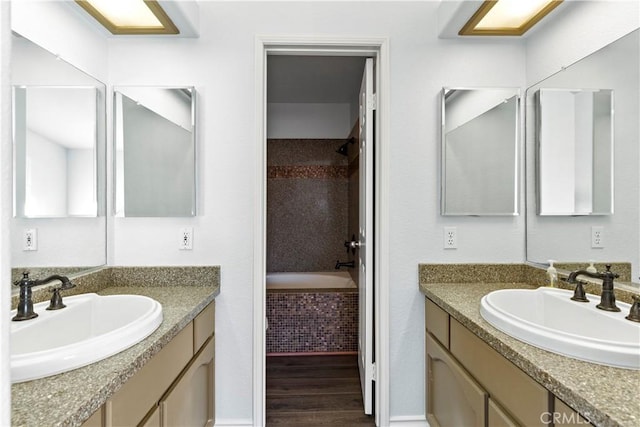 bathroom with vanity, hardwood / wood-style floors, and tiled tub