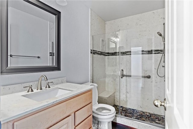 bathroom featuring vanity, toilet, and an enclosed shower