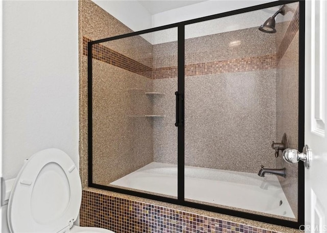 bathroom featuring enclosed tub / shower combo and toilet