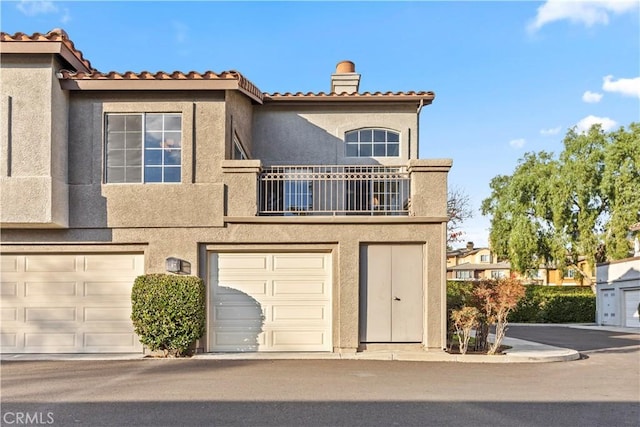 view of front of property featuring a garage and a balcony