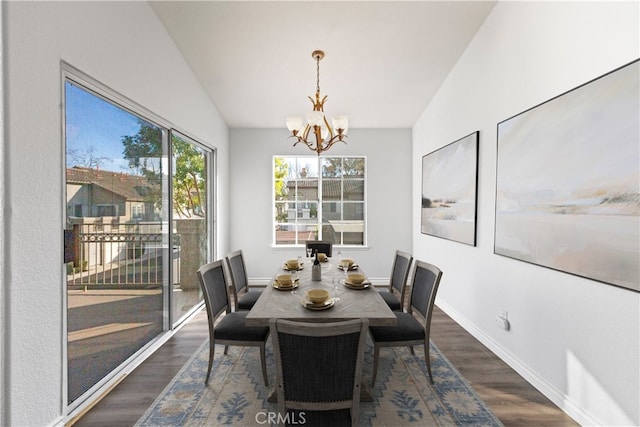 dining area featuring an inviting chandelier, dark wood-type flooring, and lofted ceiling