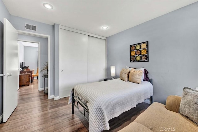 bedroom with dark hardwood / wood-style floors and a closet