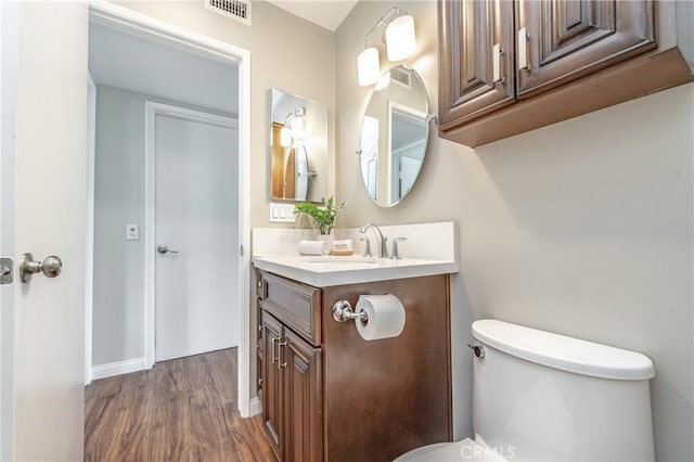 bathroom with vanity, hardwood / wood-style floors, and toilet