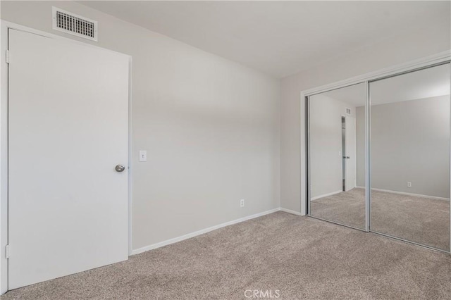 unfurnished bedroom featuring carpet flooring and a closet