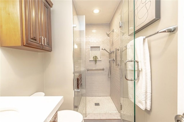 bathroom with toilet, vanity, and a shower with shower door