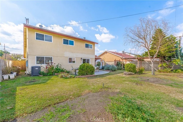 rear view of property featuring central AC and a lawn