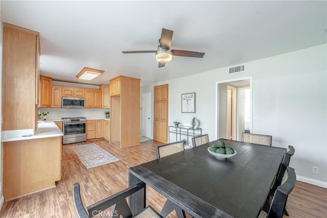 dining space featuring ceiling fan and light wood-type flooring