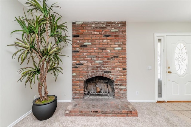 carpeted foyer entrance with a brick fireplace