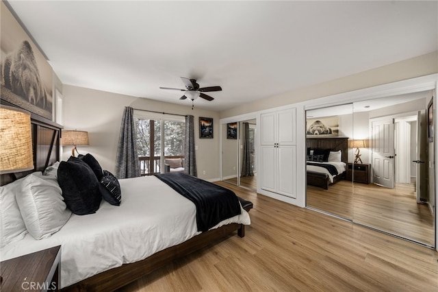 bedroom featuring multiple closets, ceiling fan, and light hardwood / wood-style floors