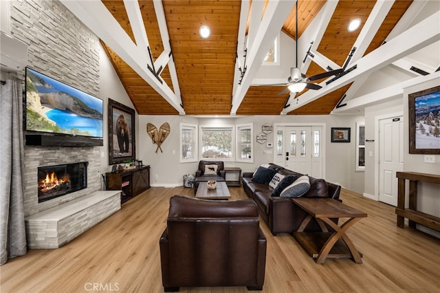 living room featuring beam ceiling, ceiling fan, a fireplace, and light hardwood / wood-style flooring