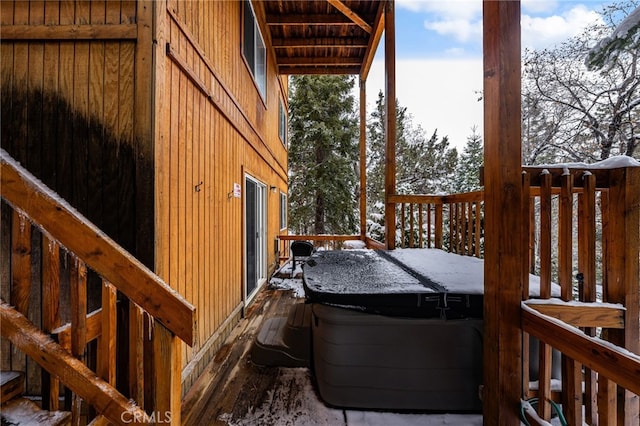 snow covered deck with a hot tub