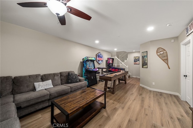 living room with ceiling fan and light hardwood / wood-style flooring